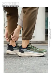 Gedetailleerde weergave van olijfgroene casual hardloopsneakers met brede neus op een model buiten.