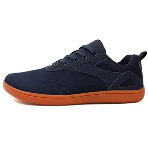Side view of navy blue barefoot sports shoes with durable orange soles