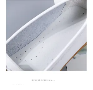 Detail van het ademende uitgesneden geperforeerde ontwerp op de witte damesloafers