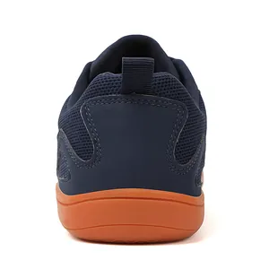 Rear view detail showing the mesh upper and orange sole of a navy breathable shoe