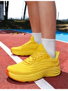 Gros plan de chaussures de sport jaunes pour hommes sur une piste d'athlétisme rouge.