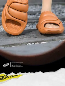 Close-up detail of orange thick-soled EVA slides for men in a rugged outdoor setting