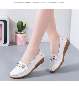 Gedetailleerd overzicht van witte leren loafers met sleehak en gouden gesp.
