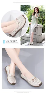 Detalle de mocasines planos beige calados con patrones cortados con láser y hebilla de metal.