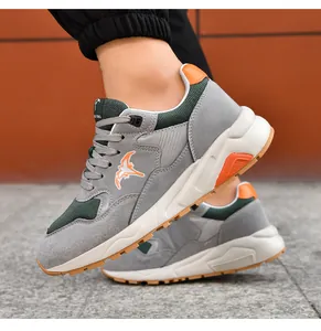 Close-up of men's lightweight grey and green casual sneakers with orange accents.