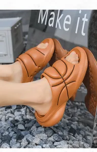 Close-up of orange basketball-style EVA slides on feet with a reflective background