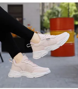 Primo piano di sneaker platform in mesh rosa traspirante indossate in ambiente urbano