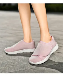 Close-up van roze ademende fly-knit wandelschoenen voor dames met verstelbare klittenbandsluiting