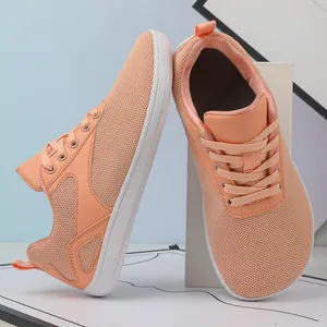 Close-up view of orange breathable flyknit sneakers featuring a comfortable wide toe box design