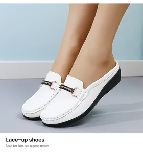 Detailansicht von weißen Slippern aus Kunstleder mit stilvoller goldener Metallschnalle.