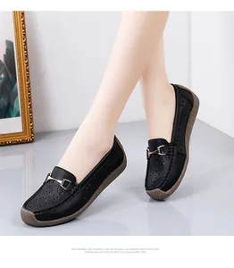 Vista detallada de mocasines de cuero negro calados con elegante hebilla dorada