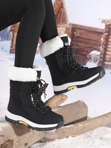 Close-up of black women's outdoor snow boots featuring white faux fur lining and sturdy soles.