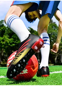 Nahaufnahme von Jugend-Fußballschuhen mit langlebigen Stollen auf einem Rasenplatz