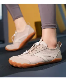 Primo piano di scarpe fitness beige traspiranti a piedi nudi su un tapis roulant in palestra