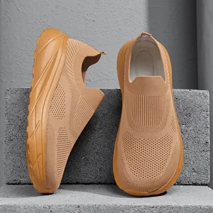 Detail view showing breathable fly-knit texture of tan slip-on men's sports shoes