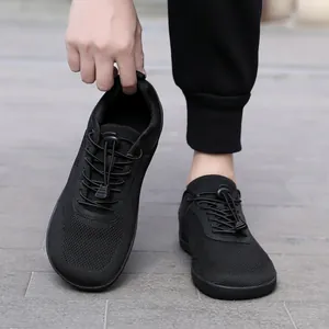 Λεπτομερής όψη μαύρων παπουτσιών barefoot με ελαστικά κορδόνια και φαρδύ μπροστινό μέρος.