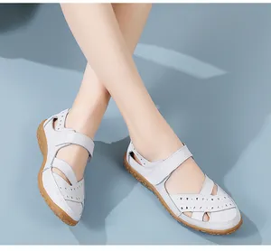 Close-up of white leather nursing sandals with hollow-out pattern and rubber sole