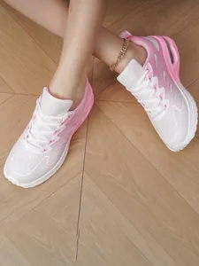 Detail view of pink and white breathable mesh running shoes on model