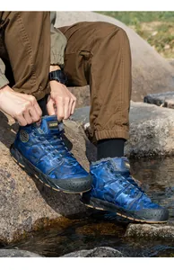 Detail view of men's waterproof blue camouflage snow boots for outdoor winter wear.