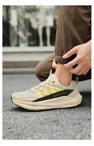 Gedetailleerd zijaanzicht van stijlvolle beige sneakers met gele accenten en zool.