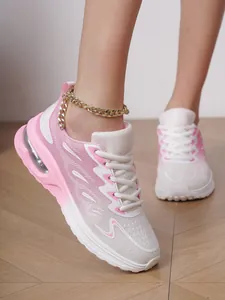 Close-up of stylish pink and white mesh running shoes for women with gold chain detail