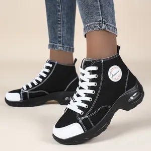 Vista dettagliata di sneaker alte in tela nera con lacci bianchi e cuscinetto d'aria
