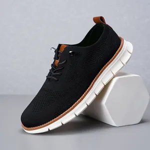 Detailed side view of black breathable mesh loafers with brown accents on white prop