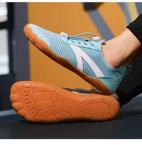 Primo piano scarpe fitness azzurre barefoot con suola in gomma arancione antiscivolo