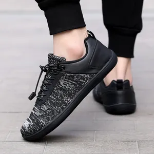 Λεπτομέρεια αναπνεύσιμων barefoot sneakers με φαρδιά μύτη και ελαστικά κορδόνια σε μαύρο γκρι