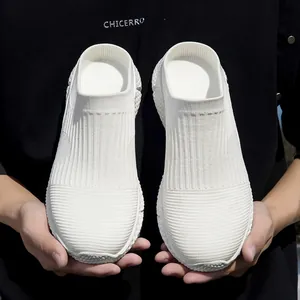 Detailed macro shot of white flyknit mesh sneakers held in hands against dark background