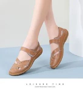 Close-up detail of brown leather sandals featuring laser-cut hollow patterns and straps