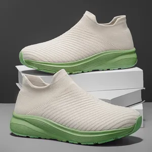 Breathable beige flyknit slip-on sneakers with wide toe and green sole on white blocks