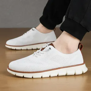 Detailed side view of white breathable mesh men's casual sneakers worn on feet with beige sole
