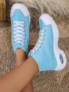 Primo piano di sneakers in tela celeste con zeppa e cuscinetto d'aria nel tallone