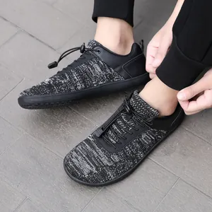 Κοντινό πλάνο γκρι πλεκτών barefoot παπουτσιών με ελαστικά κορδόνια κατά τη χρήση.