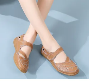Close-up of brown genuine leather hollow-out sandals featuring adjustable Velcro straps