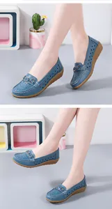 Gedetailleerd overzicht van blauwe geperforeerde wedge loafers met een metalen accent