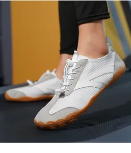 Dettaglio di scarpe da fitness bianche traspiranti con suola antiscivolo per attività indoor.