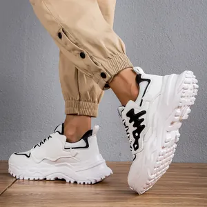 Vista dettagliata di sneakers bianche da uomo con spesse suole a piattaforma.