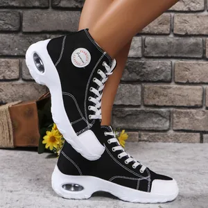 Vista laterale di scarpe di tela nere alte con suola spessa e cuscinetto d'aria