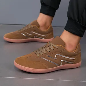 Detailed side view of brown suede casual sports shoes with silver decorative stripe.