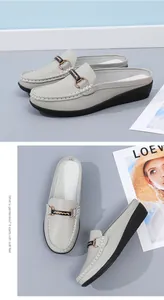 Nahaufnahme grauer Slipper mit Keilabsatz und bequemem, rückenfreiem Design für Damen