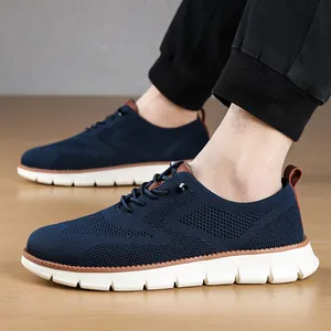 Side view of lightweight navy blue knit men's loafers with thick white soles on a wood floor.