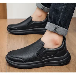 Seitenansicht schwarzer Herren-Slipper aus Leder mit dicker, rutschfester Sohle.
