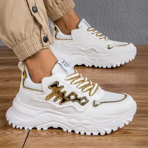 Primo piano di sneaker chunky bianche da uomo con dettagli dorati e suole spesse