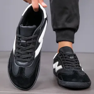 Detailed view of black and white men's wide-toe casual sports shoes with wave side design