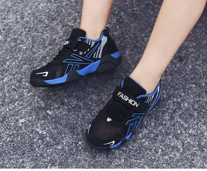 Breathable mesh sneakers for boys featuring blue accents on an outdoor asphalt road.