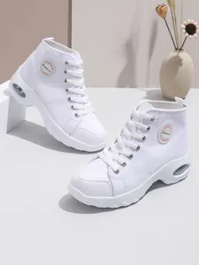Vista laterale di sneakers bianche alte da donna in tela con suola spessa e ammortizzata