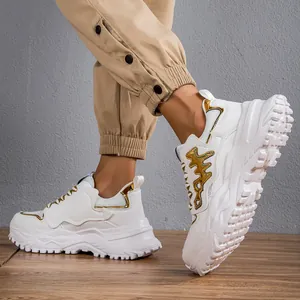 Sneakers bianche chunky da uomo con accenti dorati e una spessa suola a lisca di pesce
