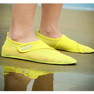 Detail shot of breathable yellow mesh beach shoes for swimming on a sandy shoreline